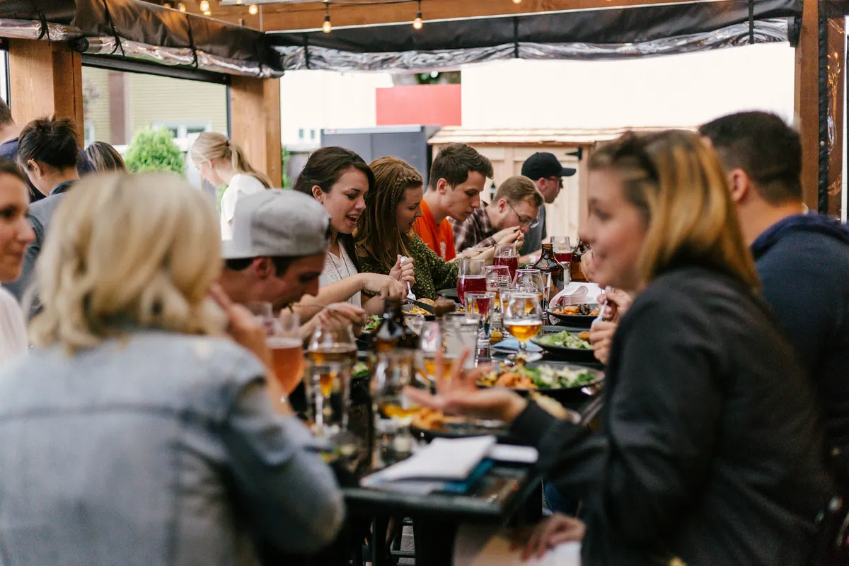 Friends gathered around a long table over dinner and drinks